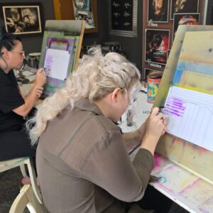 Two students practicing airbrush control exercises